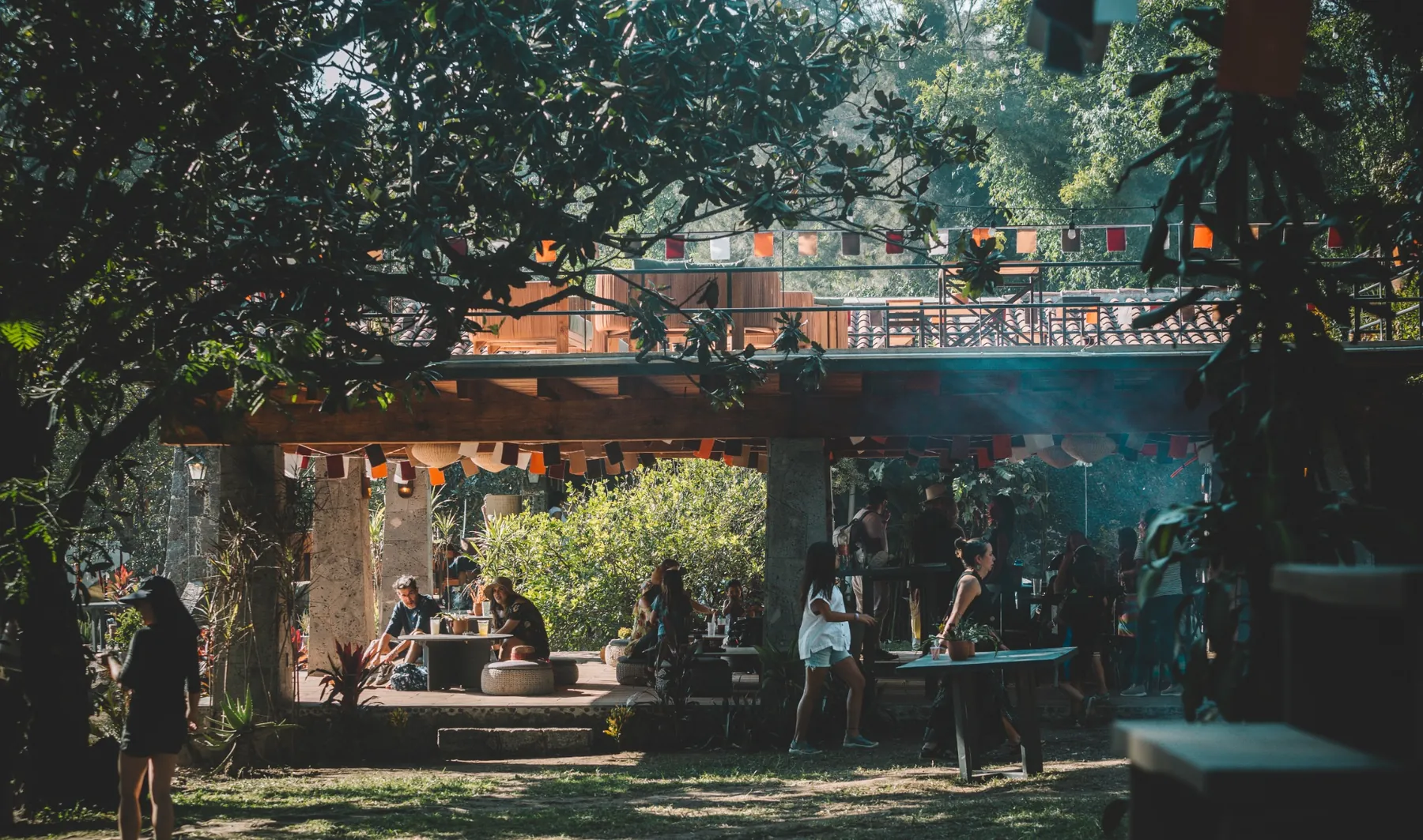 Ambiente social bajo la terraza entre árboles y banderines