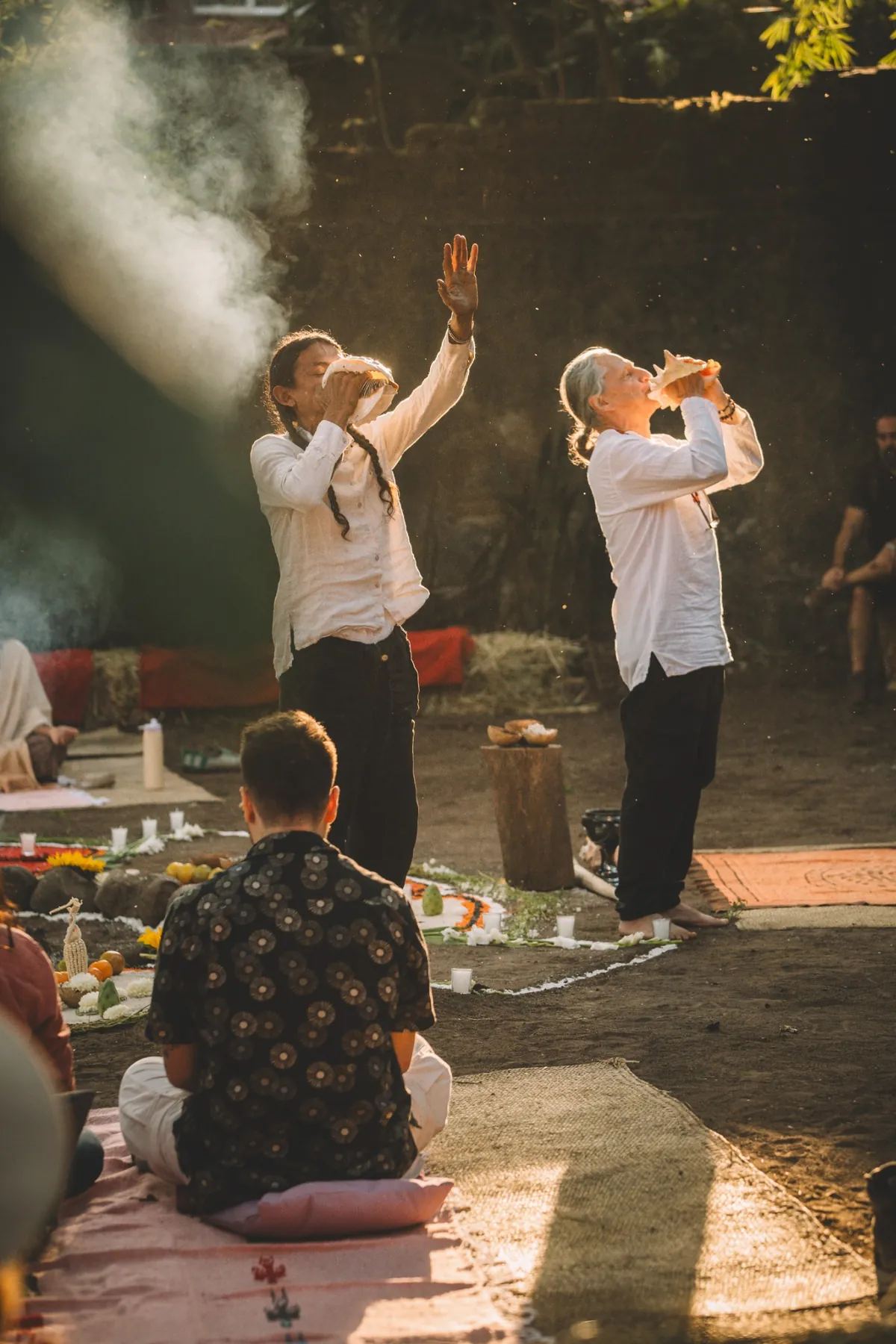 Personas facilitadoras tocando caracoles durante la ceremonia
